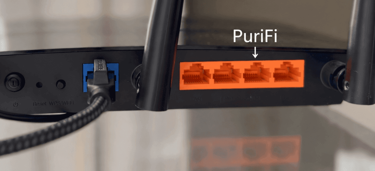 An Ethernet plug going into one of a router’s numbered LAN ports, with the modem still in the Internet port.