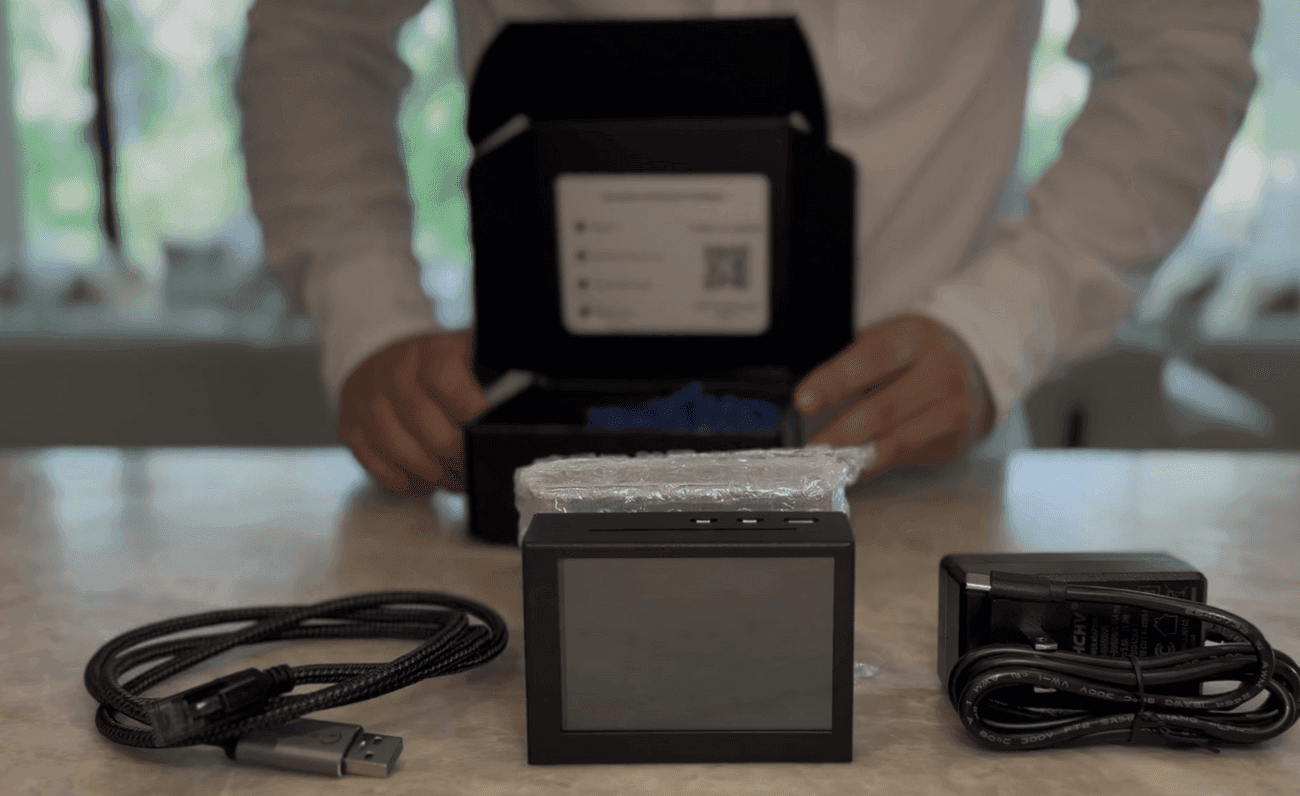 A PuriFi device beside its power supply and the USB-to-Ethernet cable.